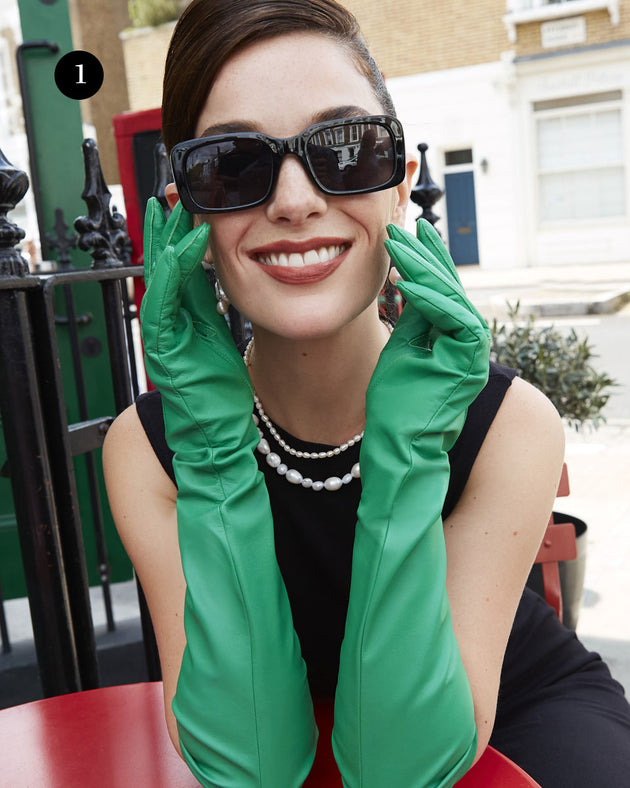 Woman wearing long leather gloves in emerald