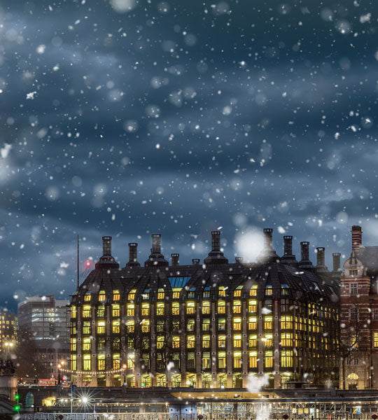 Winter Sale Graphic - Cityscape at night with illuminated building and snow falling