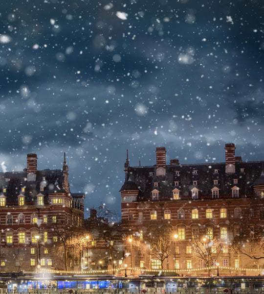 Winter Sale Graphic - Snowy night scene with illuminated buildings and falling snow.
