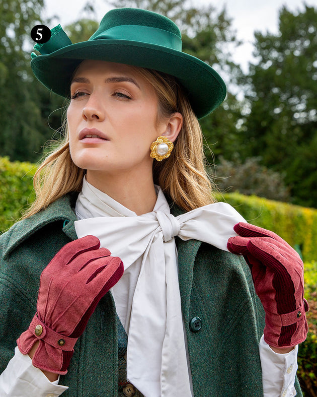 Woman wearing three point fleece lined suede gloves in claret