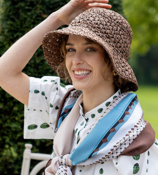 Woman wearing straw bucket hat in chocolate outside