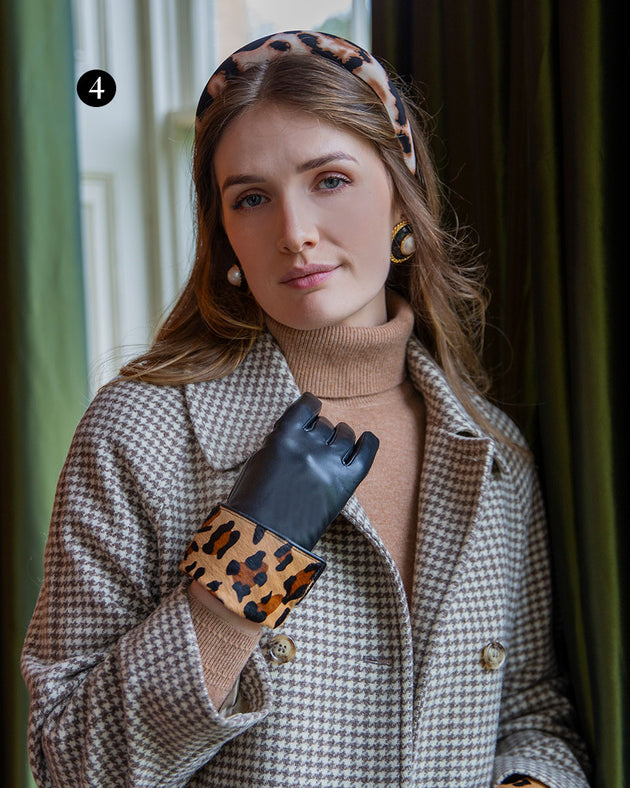 Woman wearing lined leather gloves with ponyskin leopard print cuffs in black in a grand room