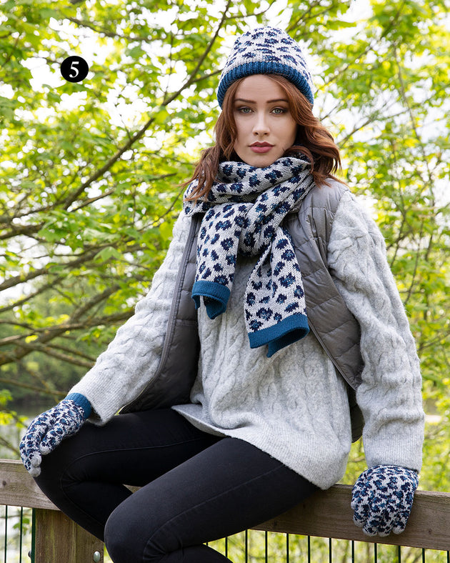 Woman wearing jacquard knitted gloves with leopard print pattern in navy in the park