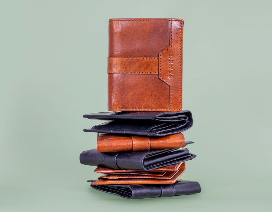 Stack of leather wallets on a light green background